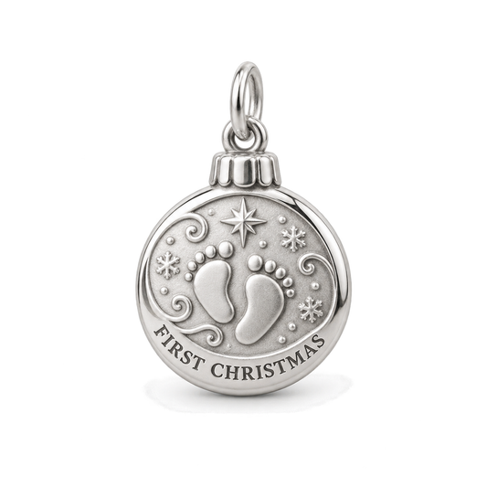 Round silver ornament charm featuring baby footprints and First Christmas engraving against a white background.