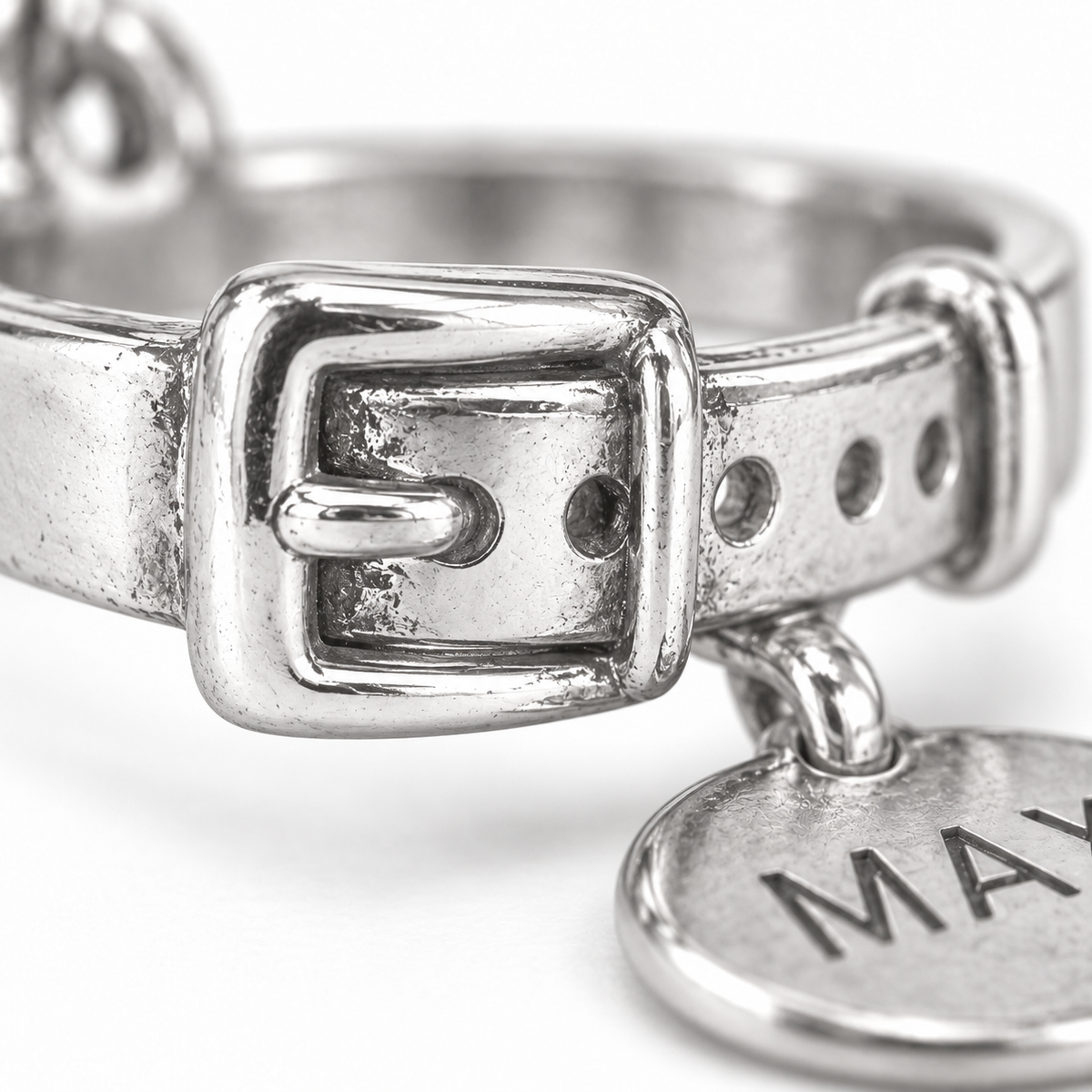 Super macro surface detail of Best Friend Collar Charm from a low oblique angle