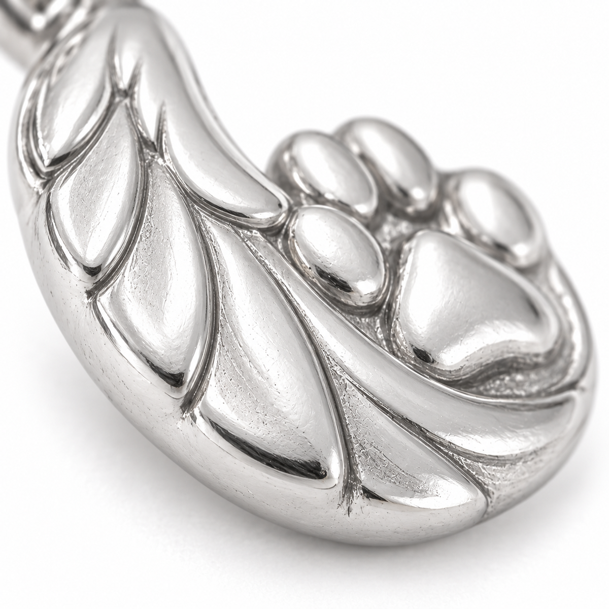 Super macro surface detail of Guardian Angel Paw Charm from a low oblique angle