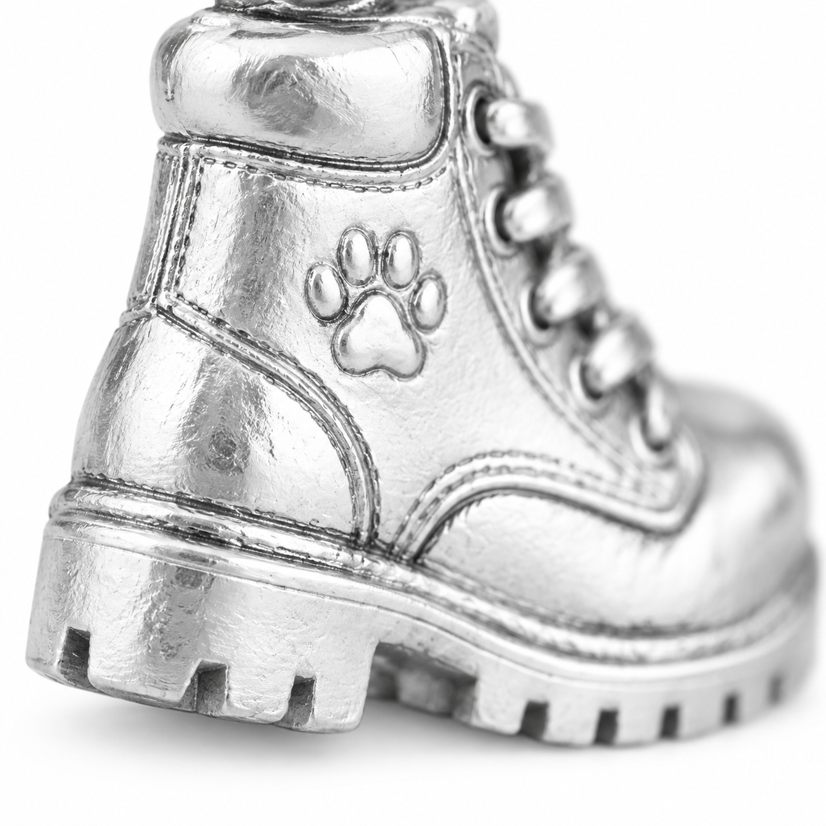 Super macro surface detail of Adventure Boots Charm from a low oblique angle