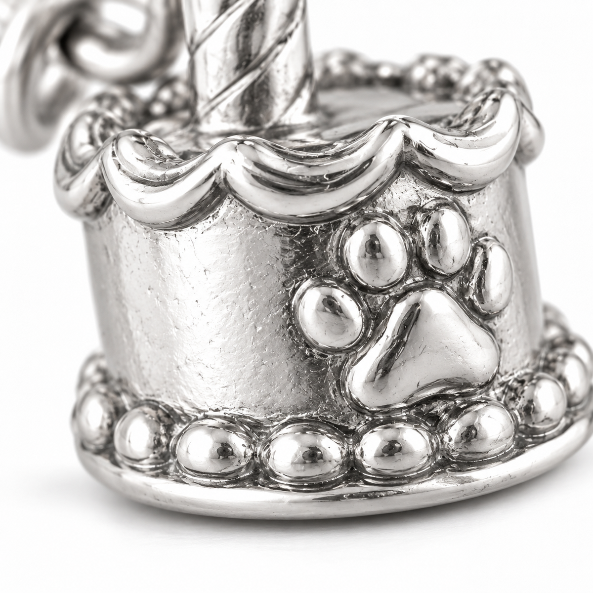 Super macro surface detail of Birthday Wishes Cake Charm from a low oblique angle