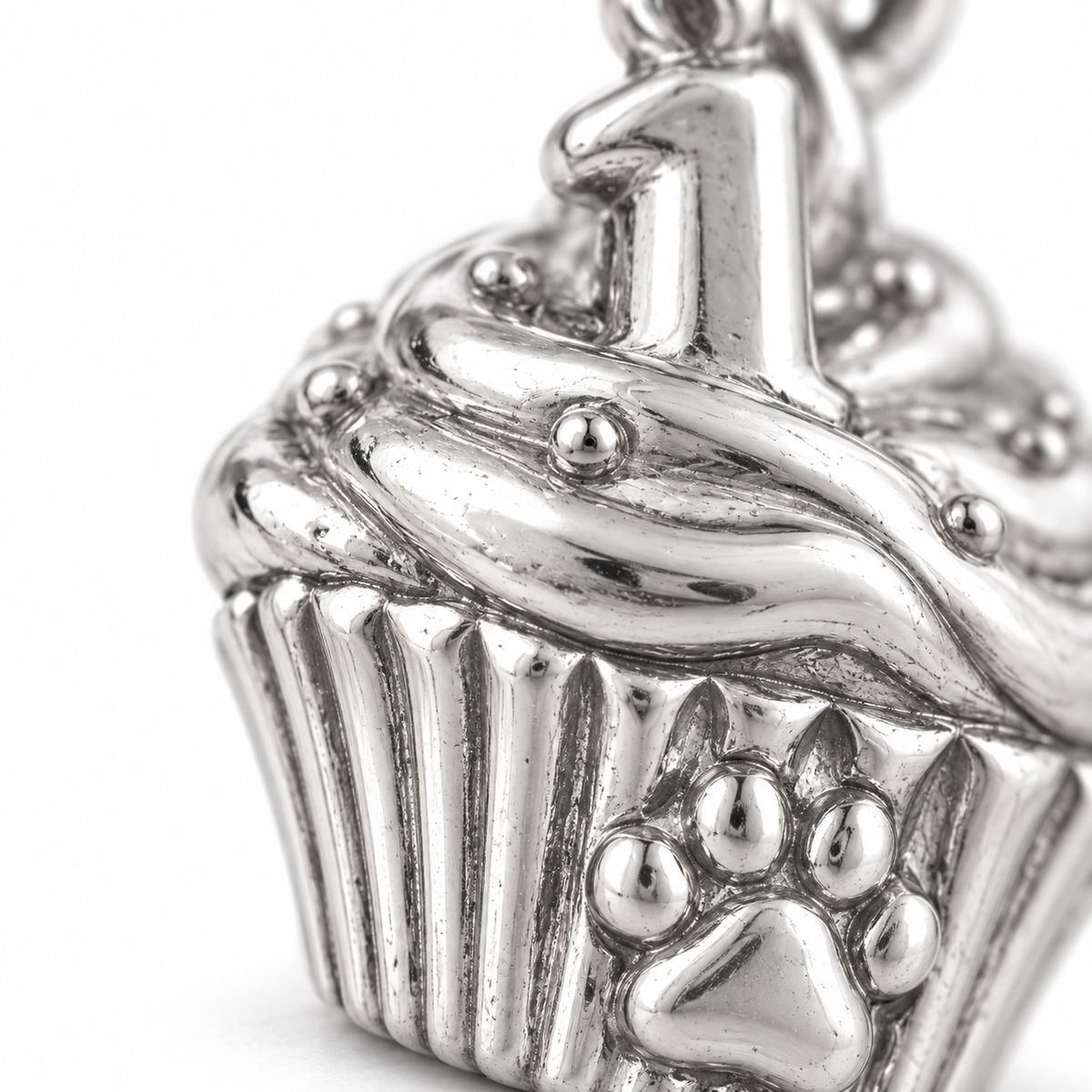 Super macro surface detail of First Pupcake Charm from a low oblique angle