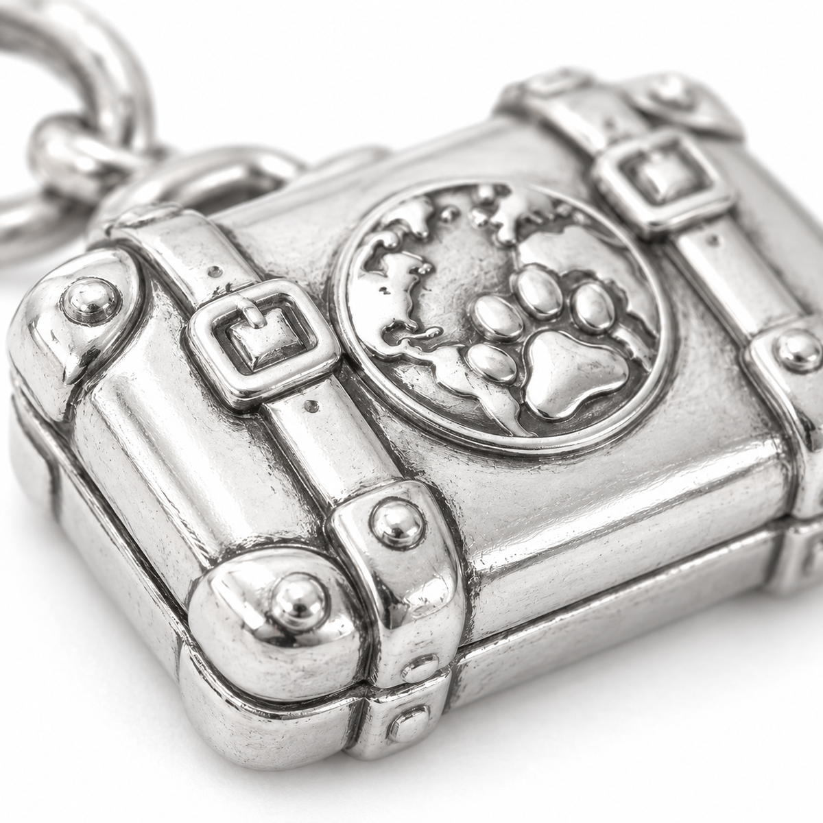 Super macro surface detail of Ready for Adventure Suitcase Charm from a low oblique angle