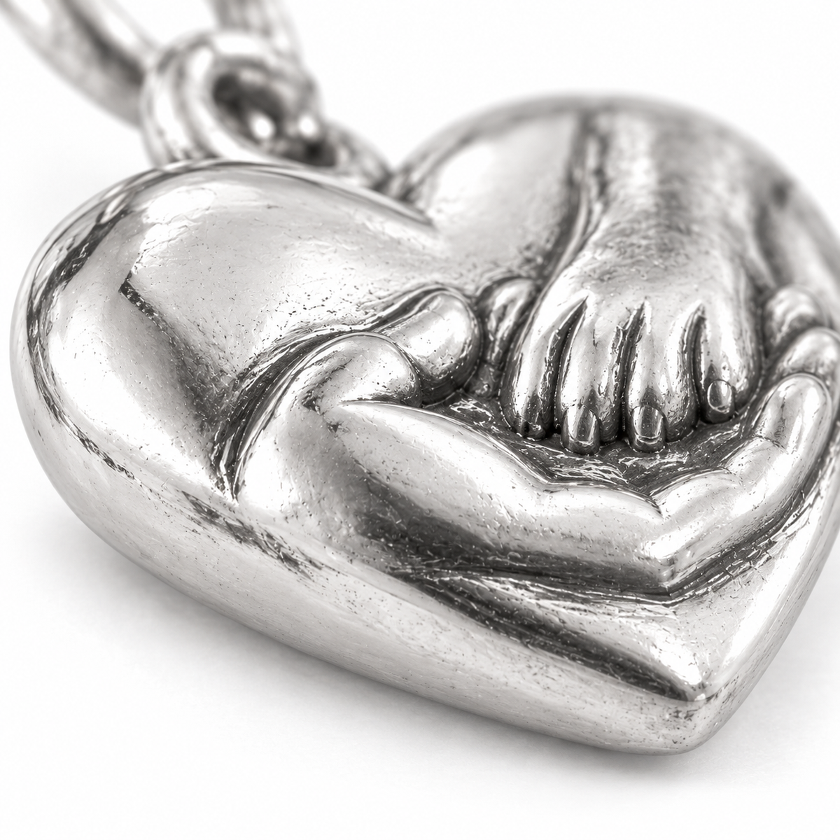 Super macro surface detail of Hand in Paw Heart Charm from a low oblique angle