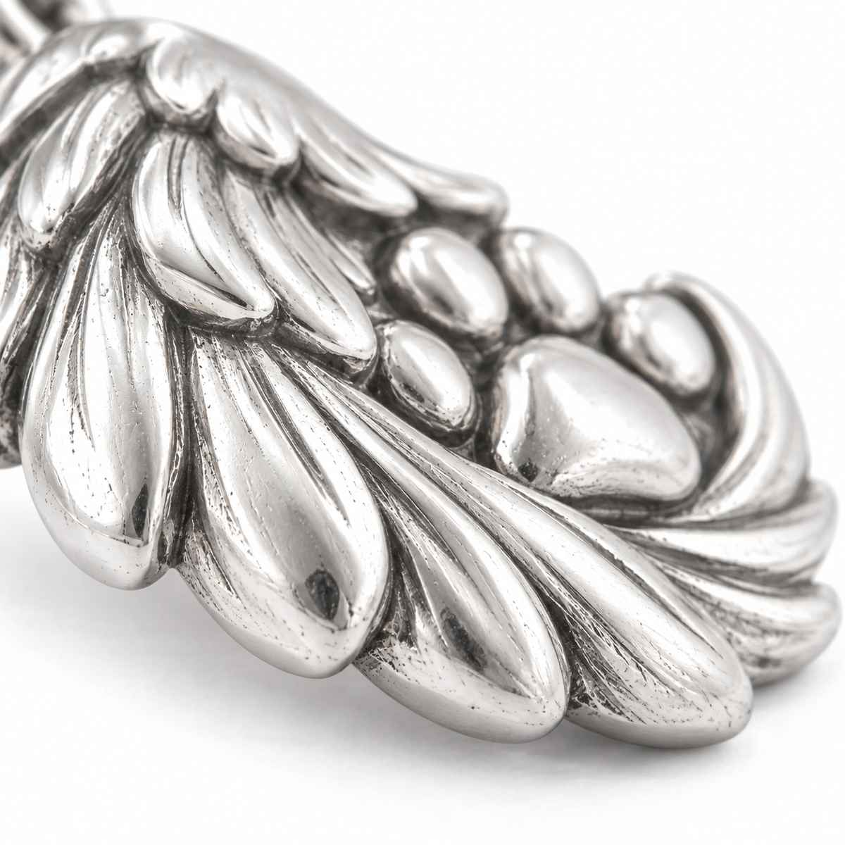 Super macro surface detail of Angel Paw Embrace Charm from a low oblique angle