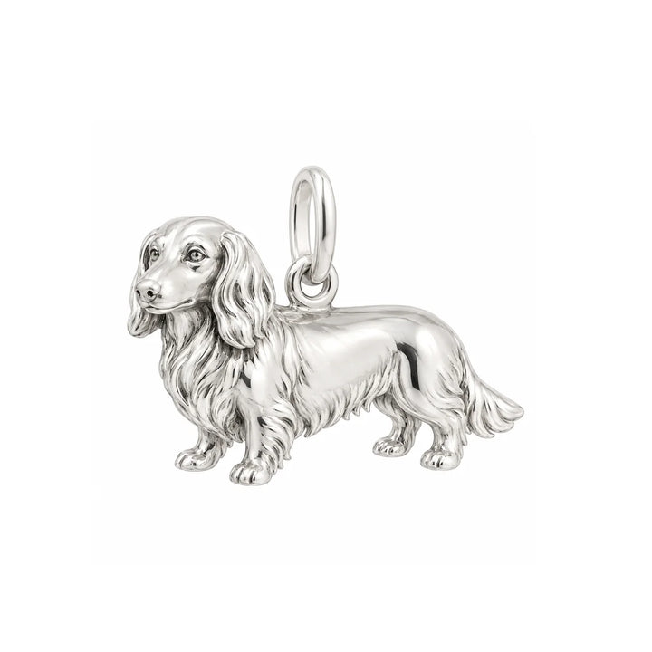 Handmade sterling silver long haired dachshund charm with detailed fur texture and polished finish.