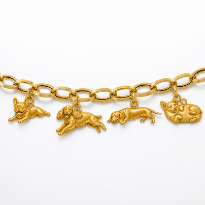 Horizontal view of four different gold dog breed charms hanging from a polished gold link chain.