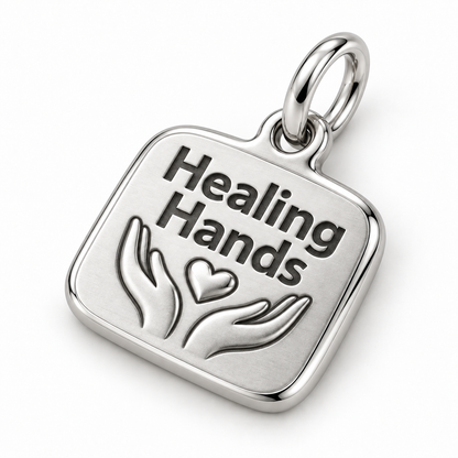 Healing Hands Engraved Nurse Charm | macro face-up oblique view | 48a6f0970b890ff9e0aa8fa6a28a6ad3a878505a0ca636eae7f091fcda32f17b