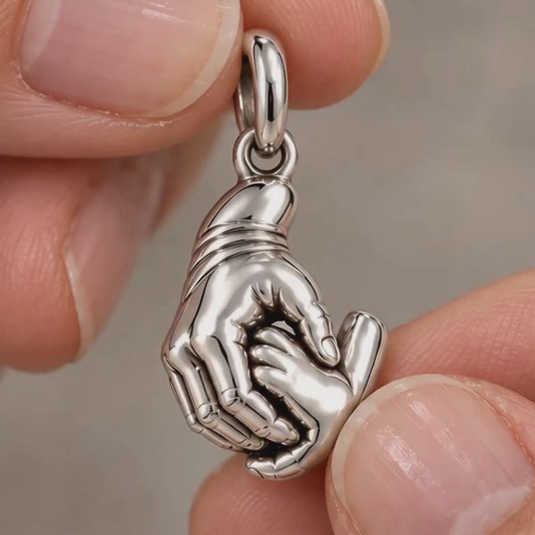 Close-up of Grandma's Holding Hands charm, its To My Granddaughter message card, and the bracelet worn on the wrist