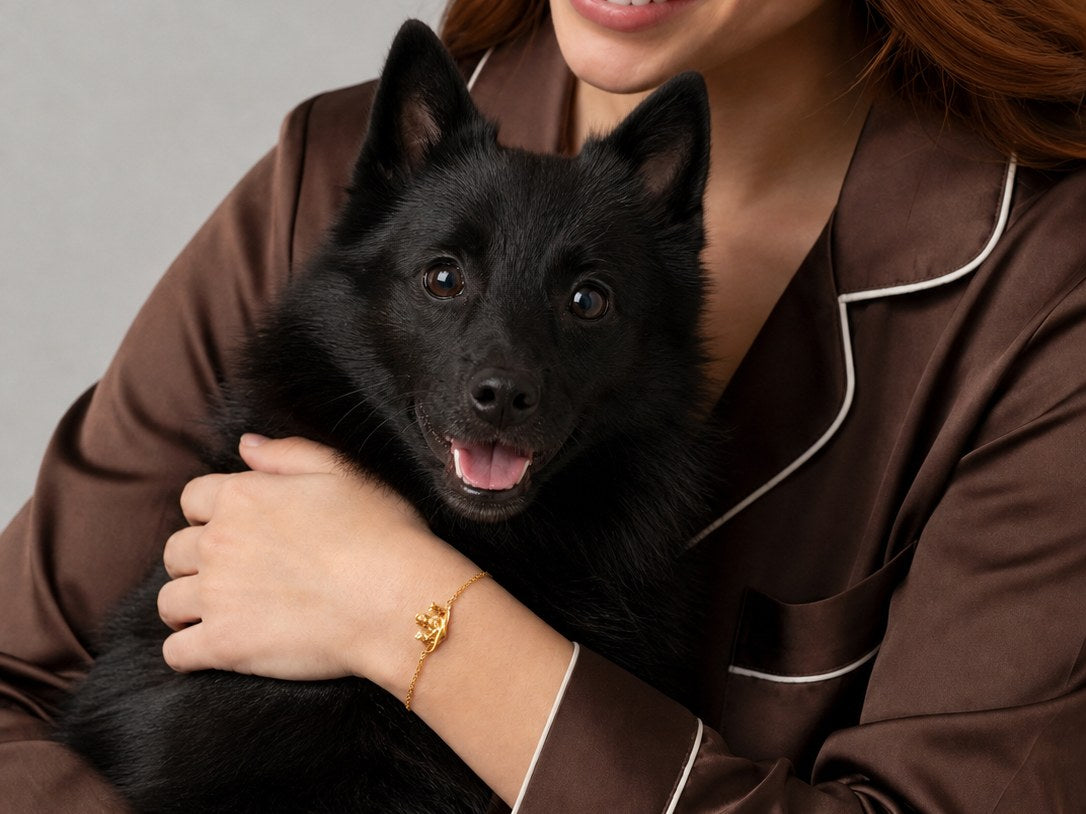 Girl wearing Soulyshine Schipperke bracelet while holding a black Schipperke